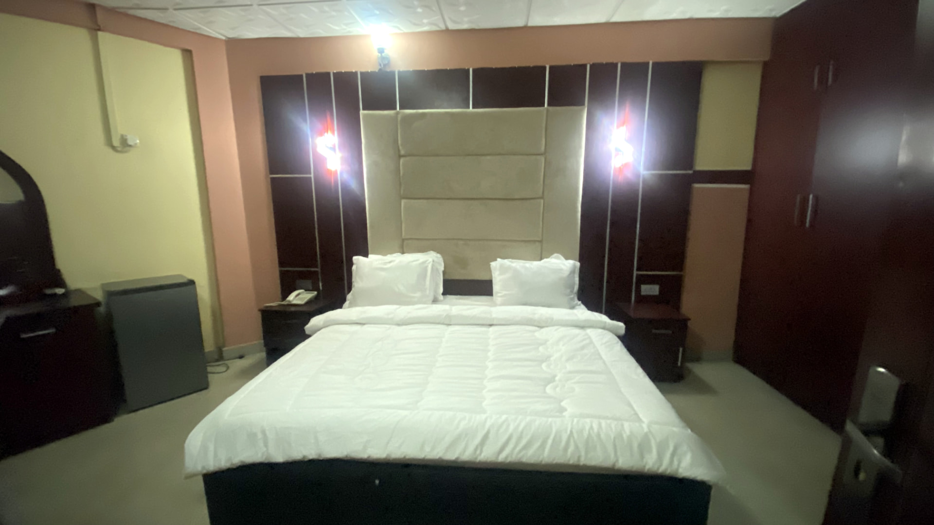 Guest room — cream headboard and wardrobes